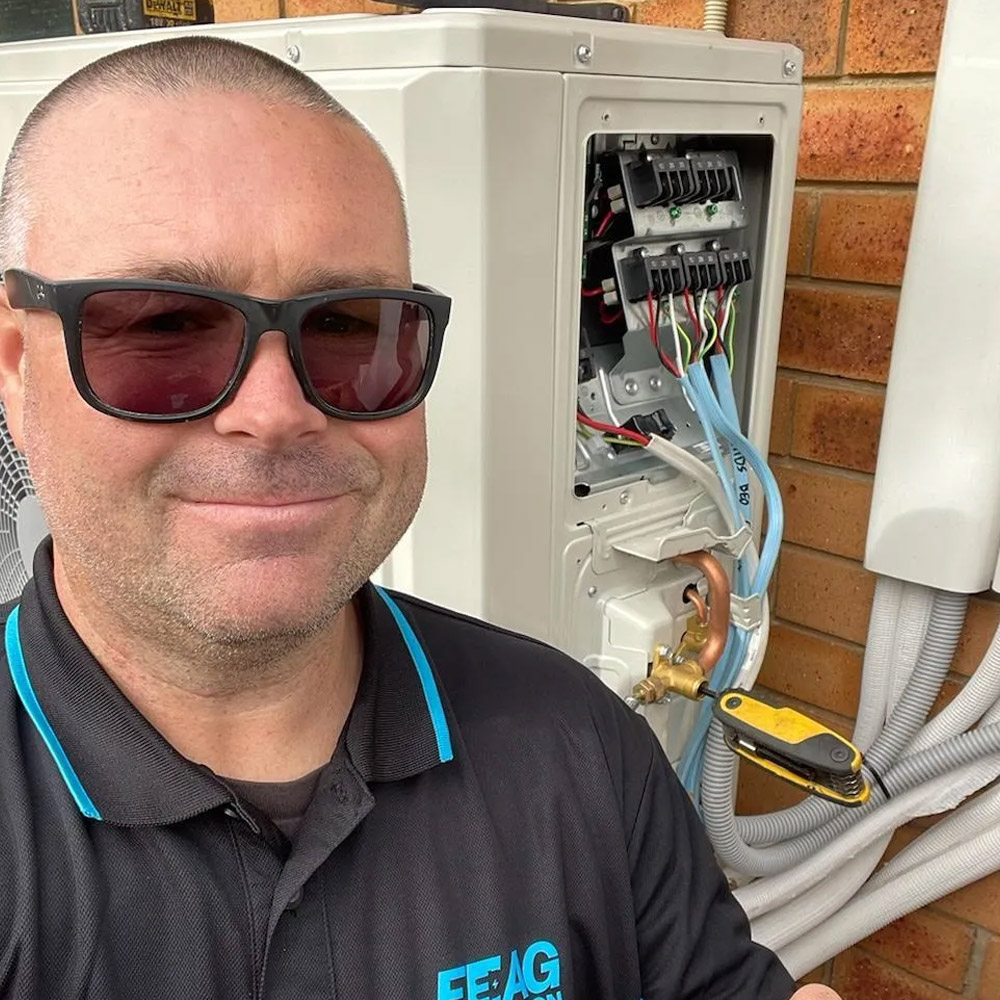 Frankston Electrical and Air Conditioning Group technician servicing an outdoor air conditioning unit in Mornington